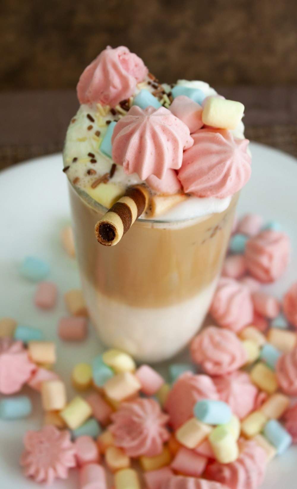 a white plate topped with a cup filled with ice cream and marshmallows