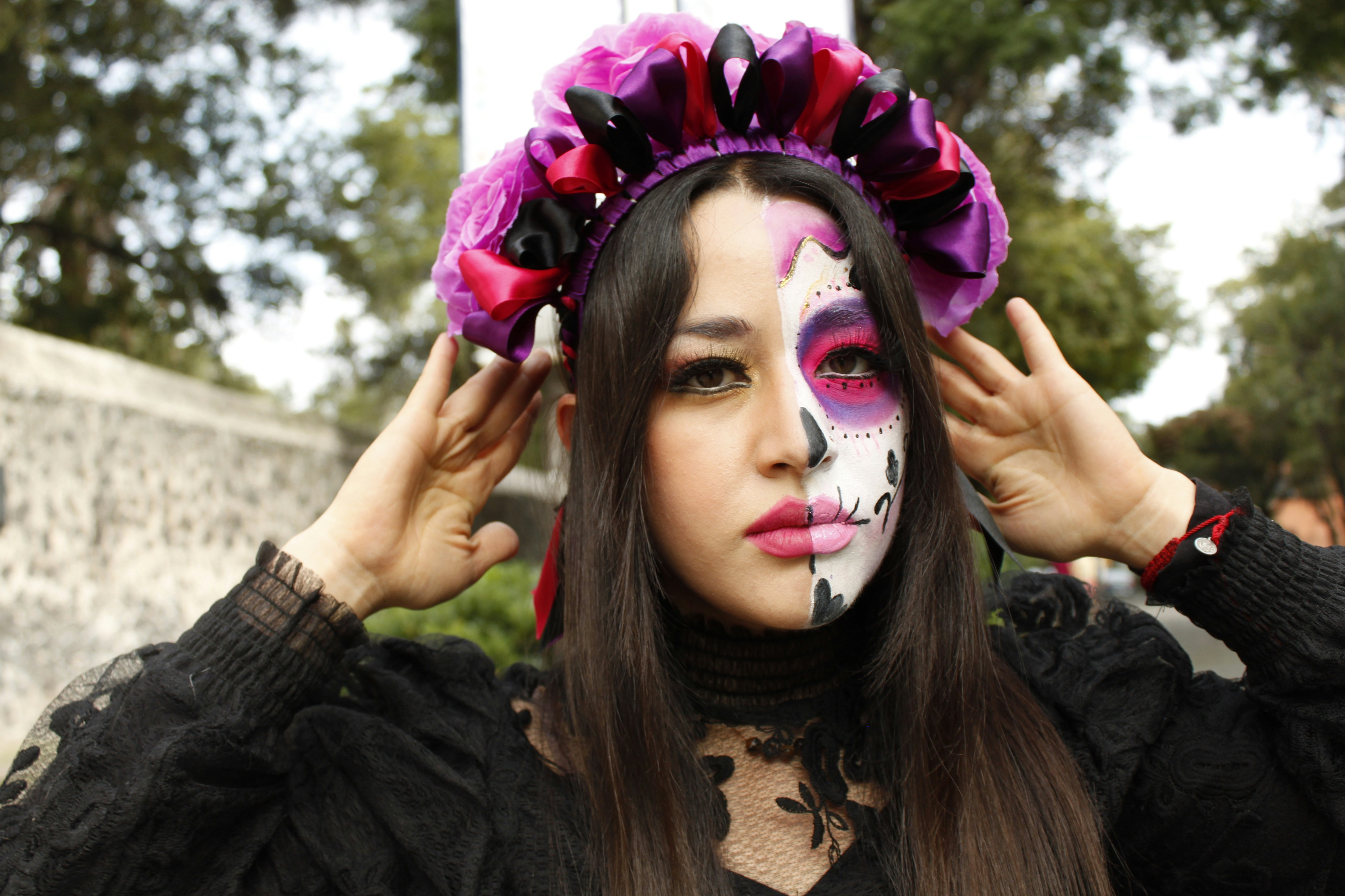 a woman with a painted face and a flower in her hair, 