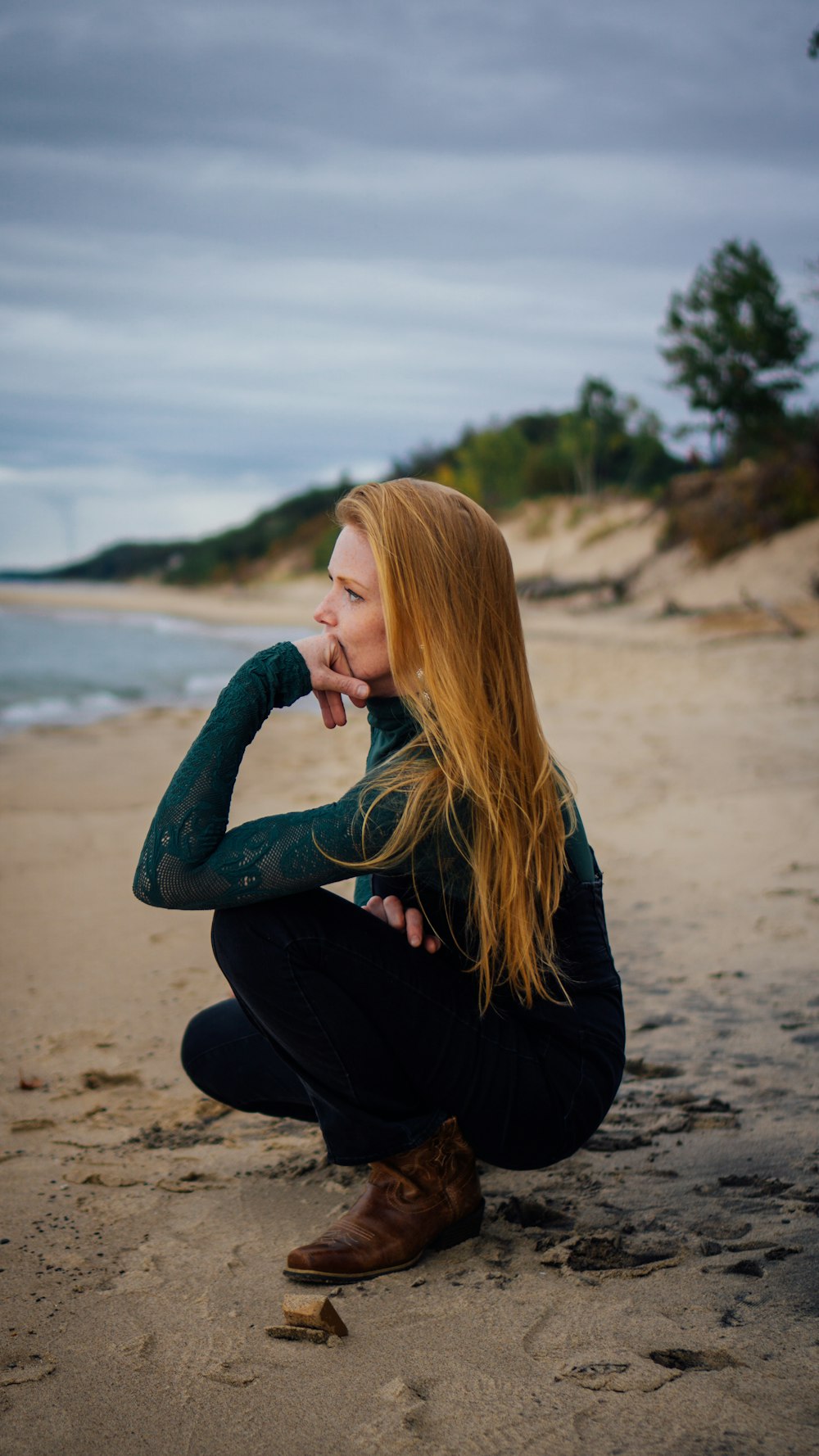 Eine Frau sitzt an einem Strand am Meer