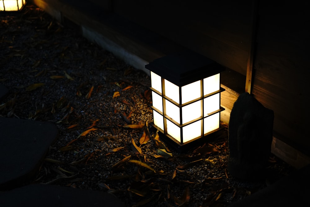 a lantern lit up in the dark on the ground