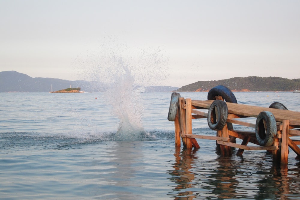 a wooden bench sitting in the middle of a body of water