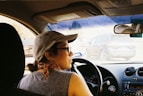 a woman driving a car in a parking lot