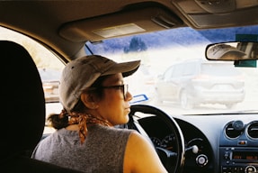 a woman driving a car in a parking lot