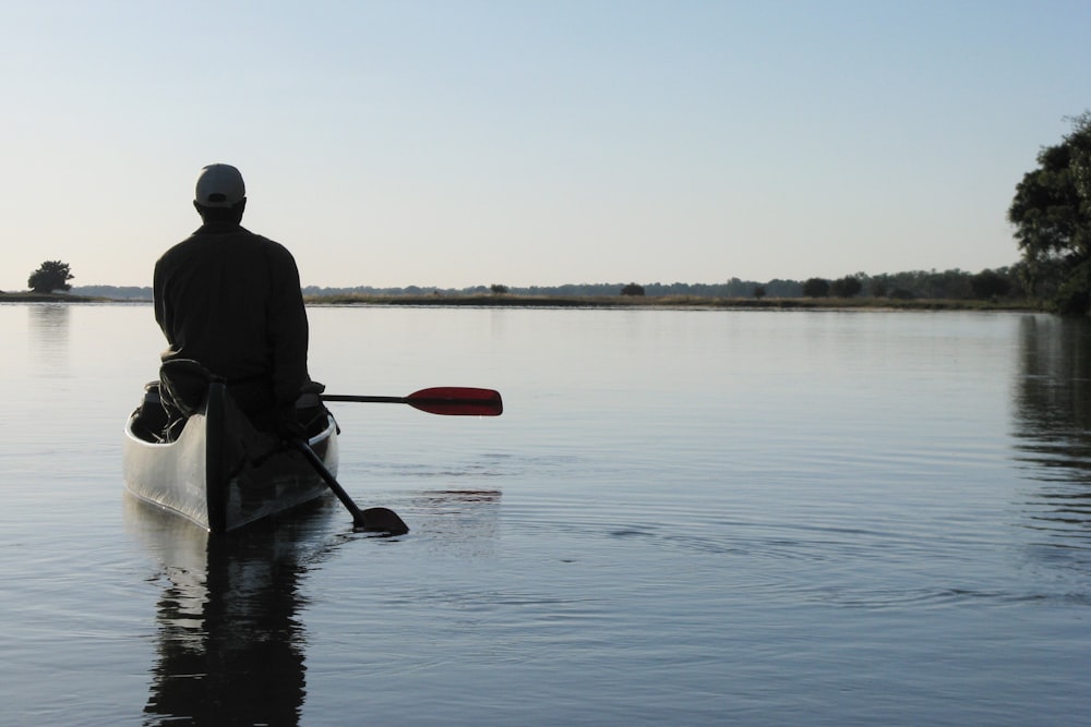 a man is paddling a canoe on the water