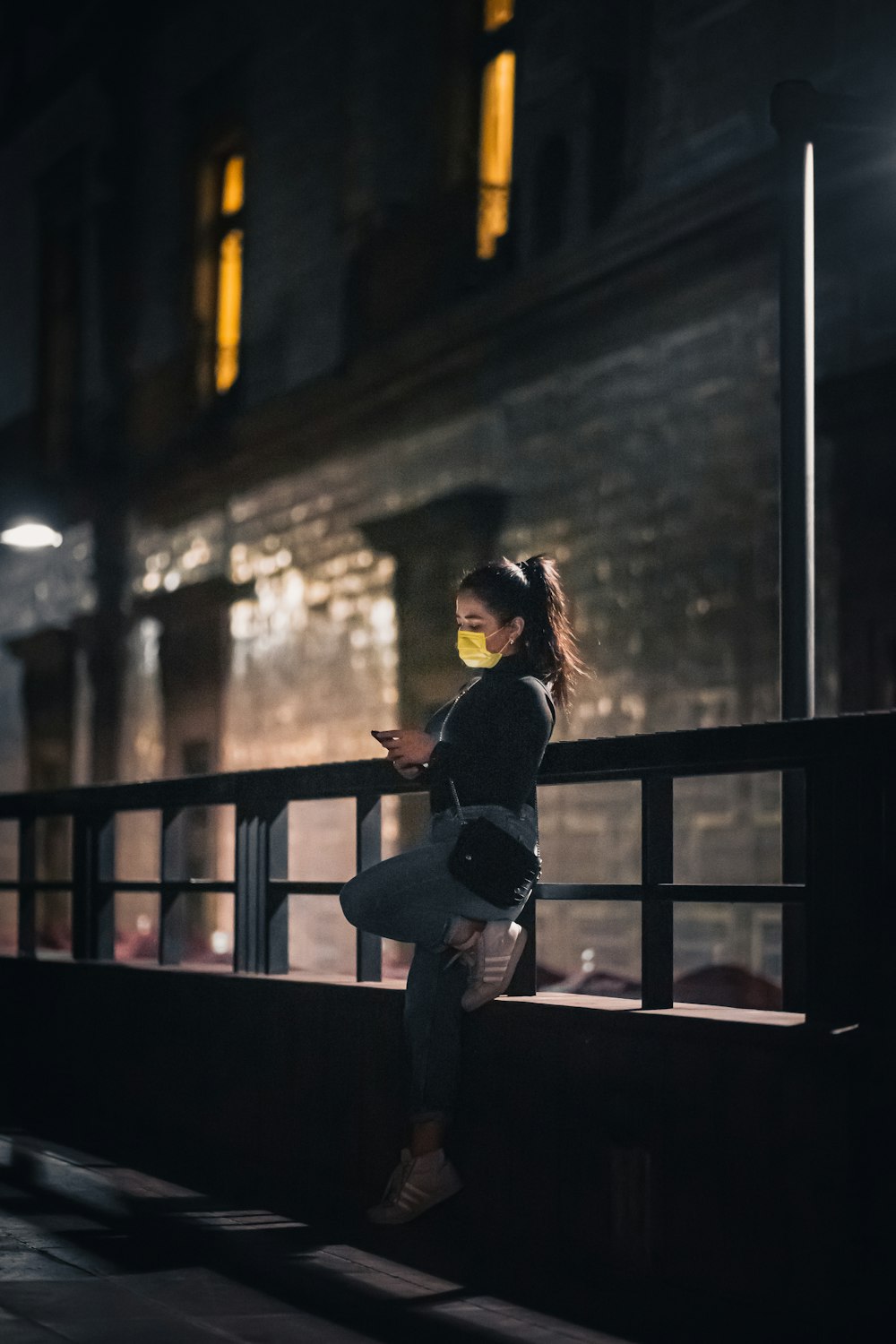 a woman standing on a balcony at night