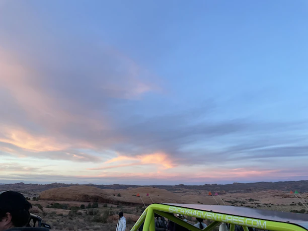 A friendly Terravise team member taking photos of a desert land parcel under a bright blue sky.