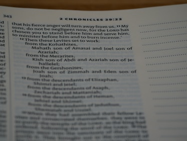 A close-up of a page from a Bible, specifically from 2 Chronicles 29:23. The text discusses instructions related to Levites and includes names like Mahath, Joel, Kish, and Joah. The page is open with text primarily on the left side, and a margin with dotted lines on the right.