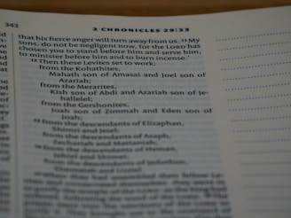 A close-up of a page from a Bible, specifically from 2 Chronicles 29:23. The text discusses instructions related to Levites and includes names like Mahath, Joel, Kish, and Joah. The page is open with text primarily on the left side, and a margin with dotted lines on the right.
