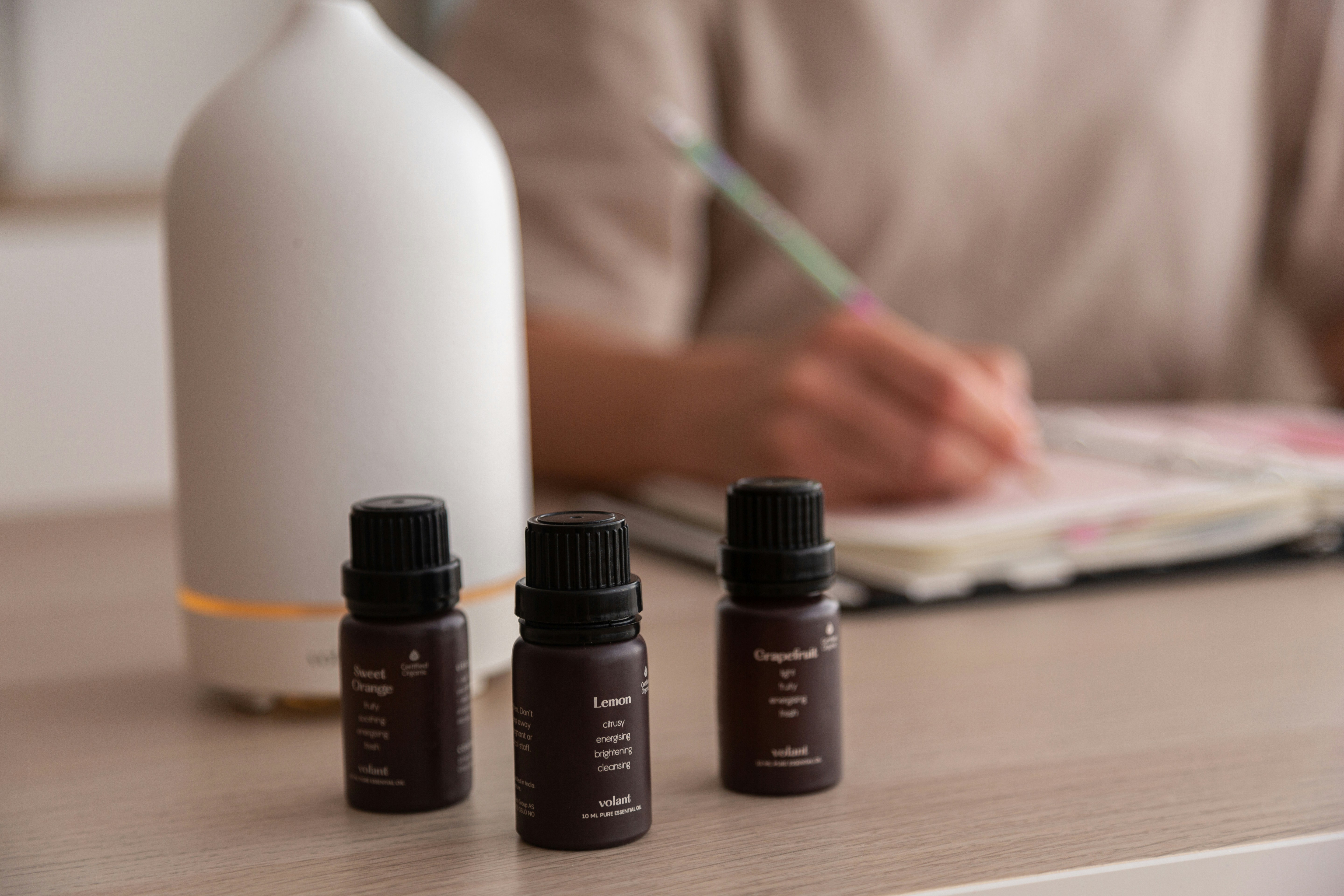 Various bottles of different massage oils displayed on a wooden table.