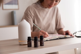 a woman sitting at a table writing on a piece of paper