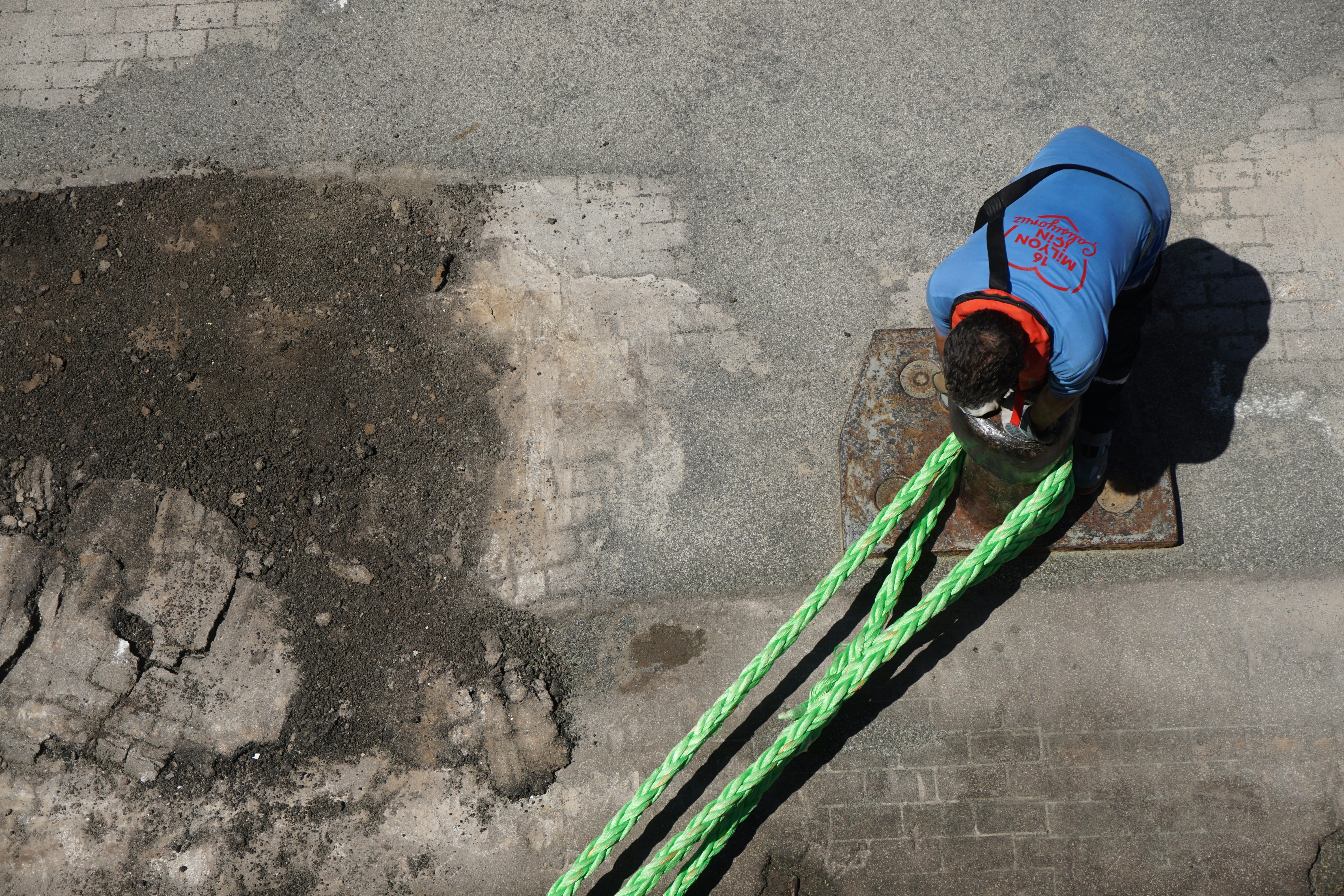 a man with a blue jacket and a green rope