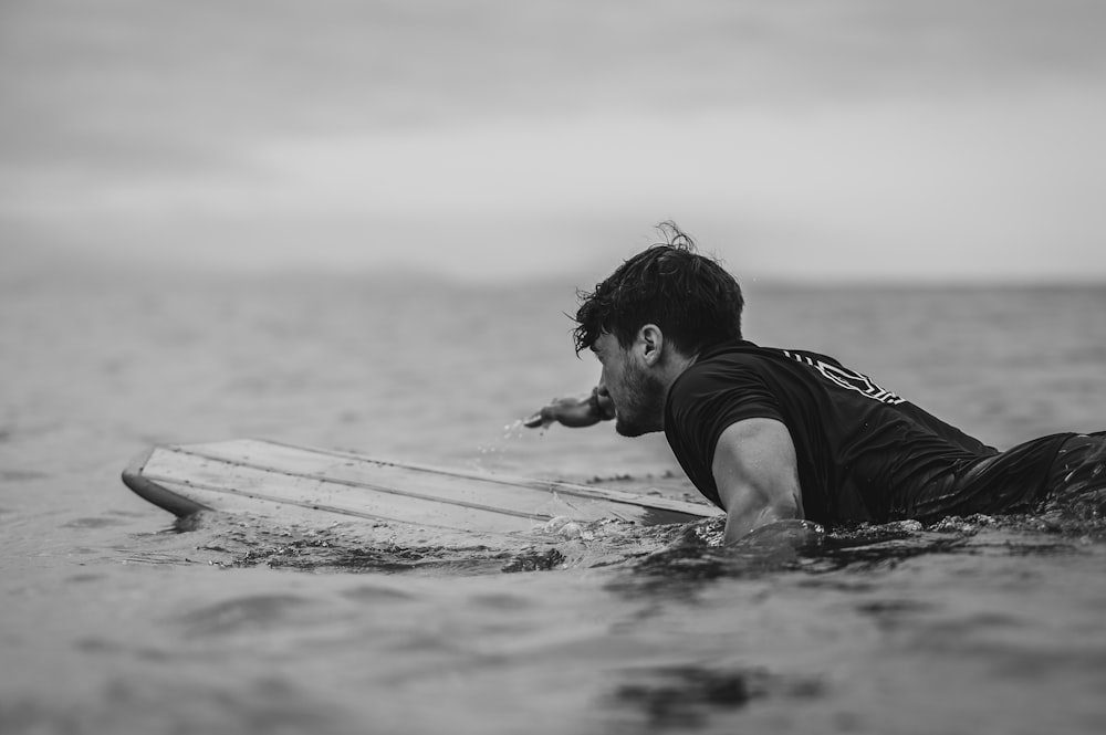 a man laying on a surfboard in the ocean
