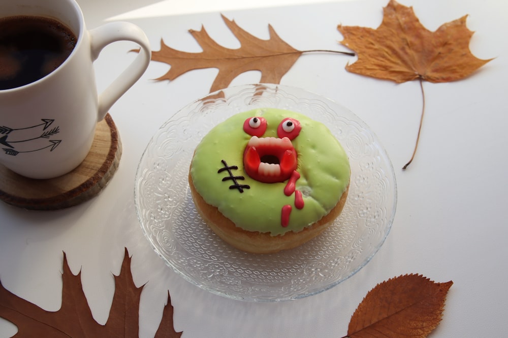 a cup of coffee and a decorated doughnut