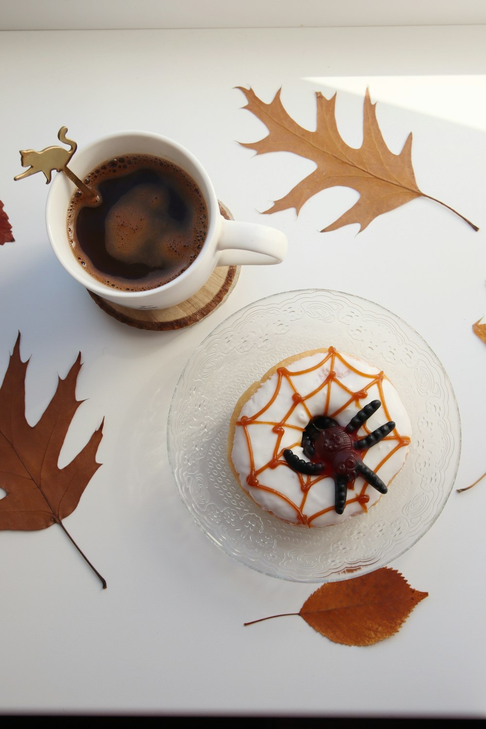 a cup of coffee sitting next to a plate with a cake on it