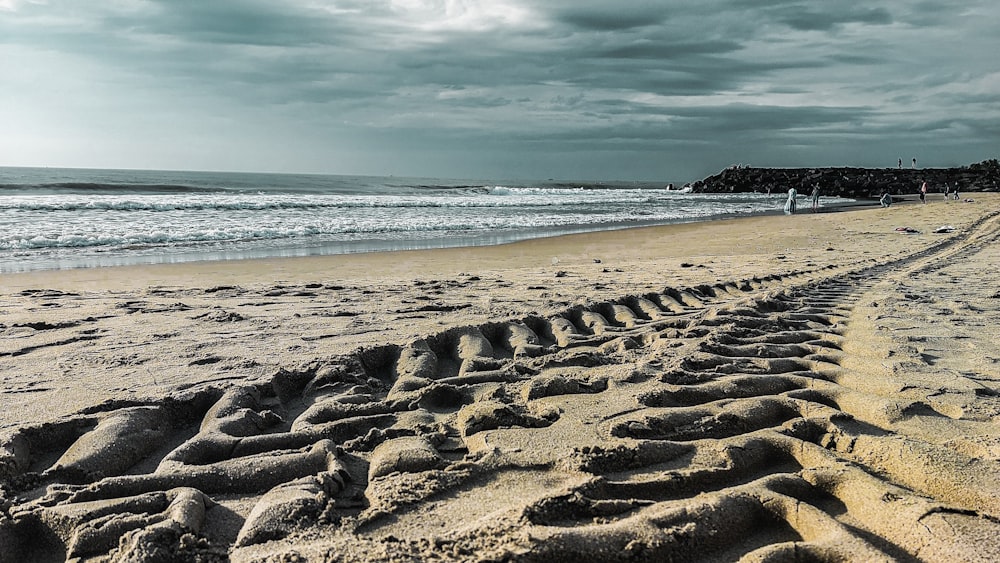 Une piste de pneus dans le sable sur une plage