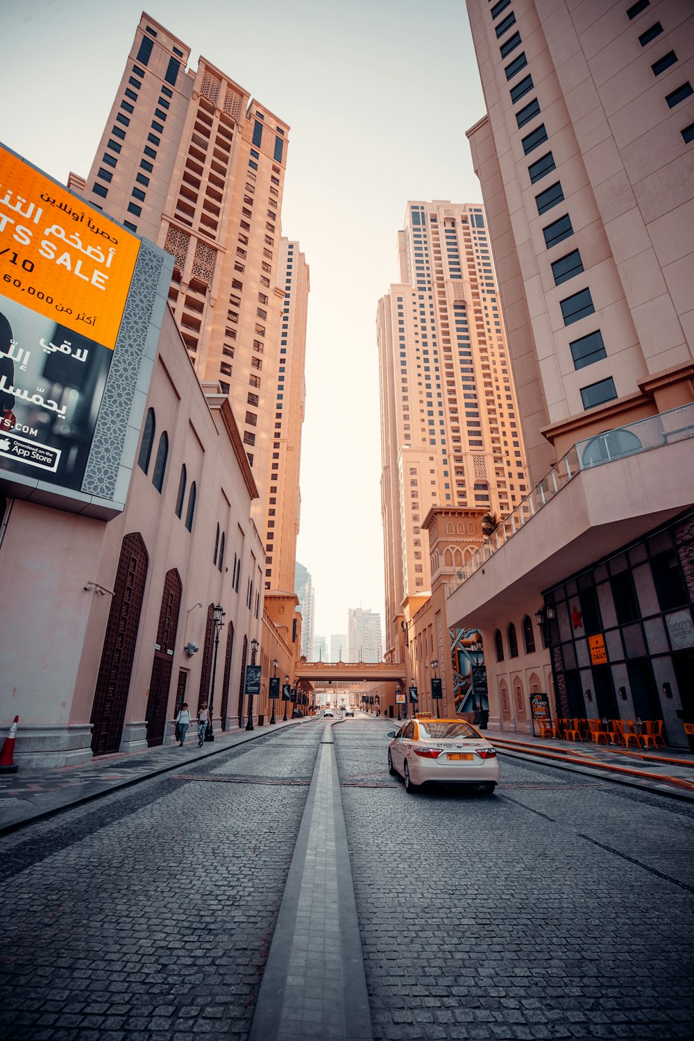 a car driving down a street next to tall buildings