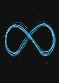 A glowing blue infinity symbol drawn against a black background using light trails.