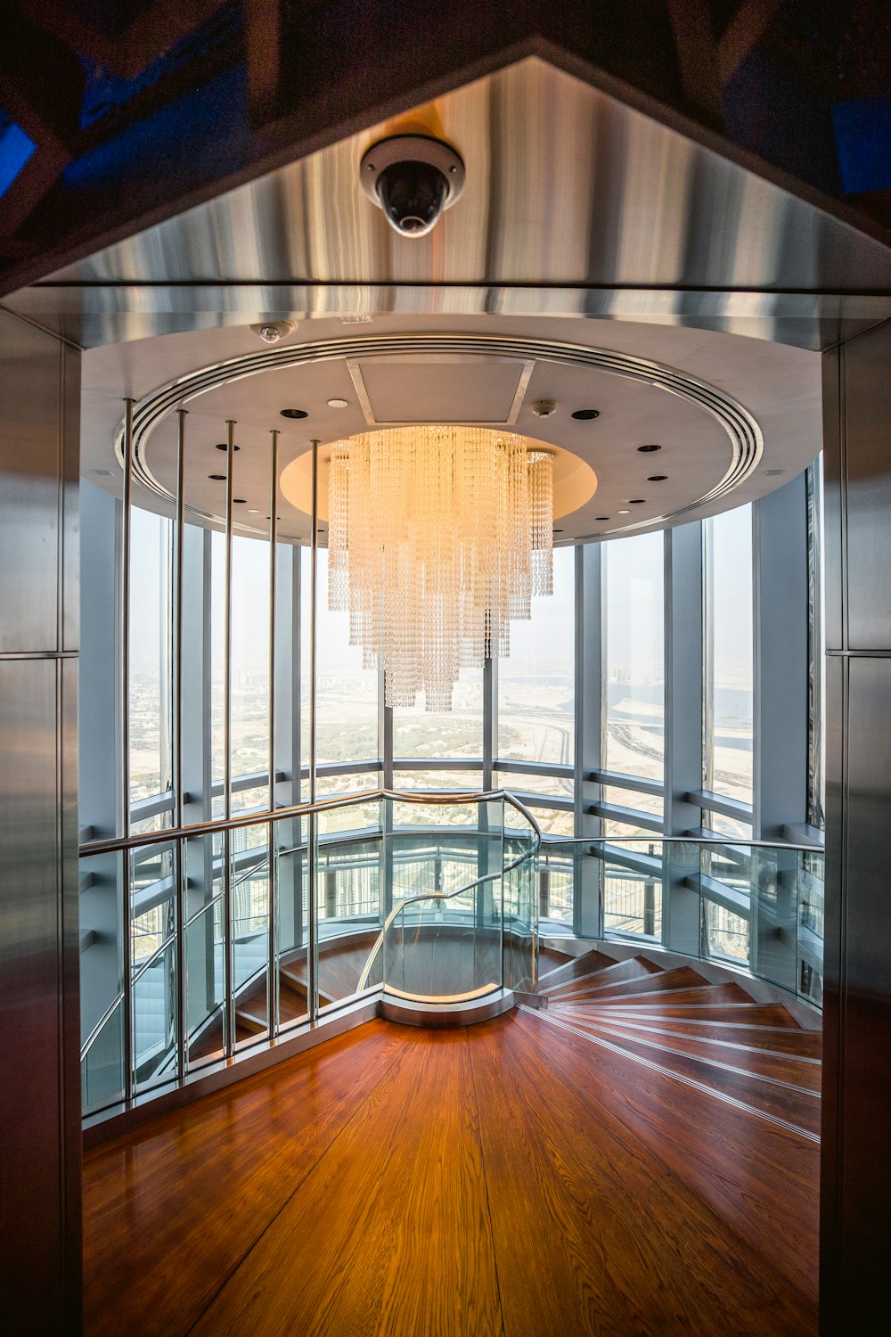 a circular room with a chandelier and wooden floors