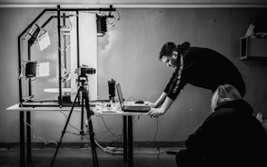 a man standing over a laptop computer on a table