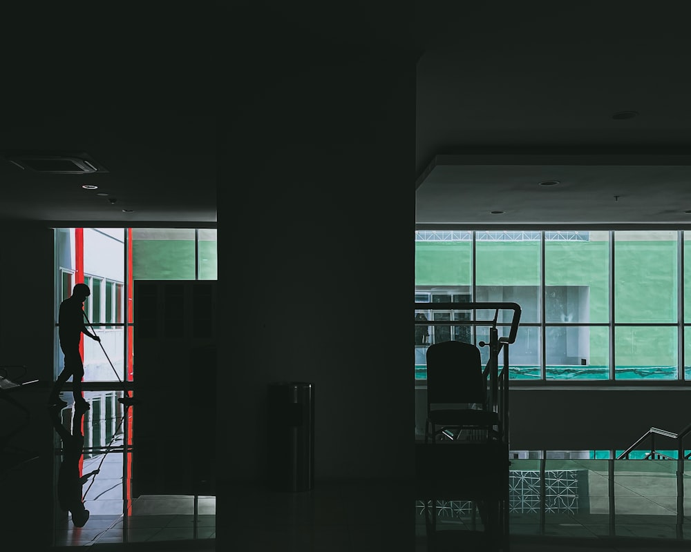 a person standing in a dark room with a chair