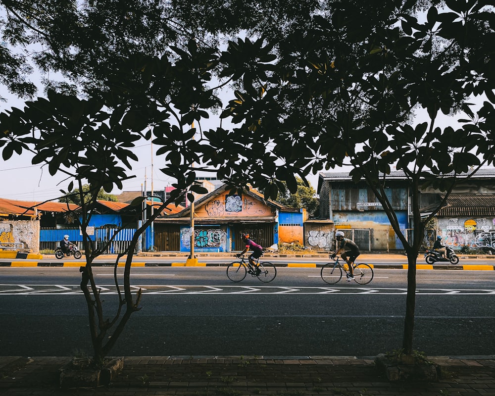 a couple of people riding bikes down a street