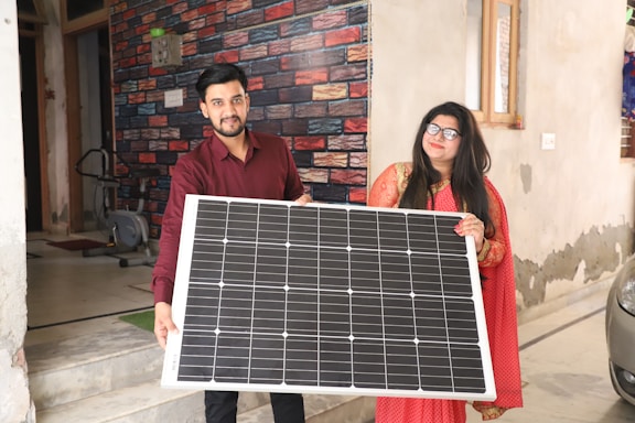 A friendly plamd energy team member assisting a customer in a bright office with solar panels visible through the window.