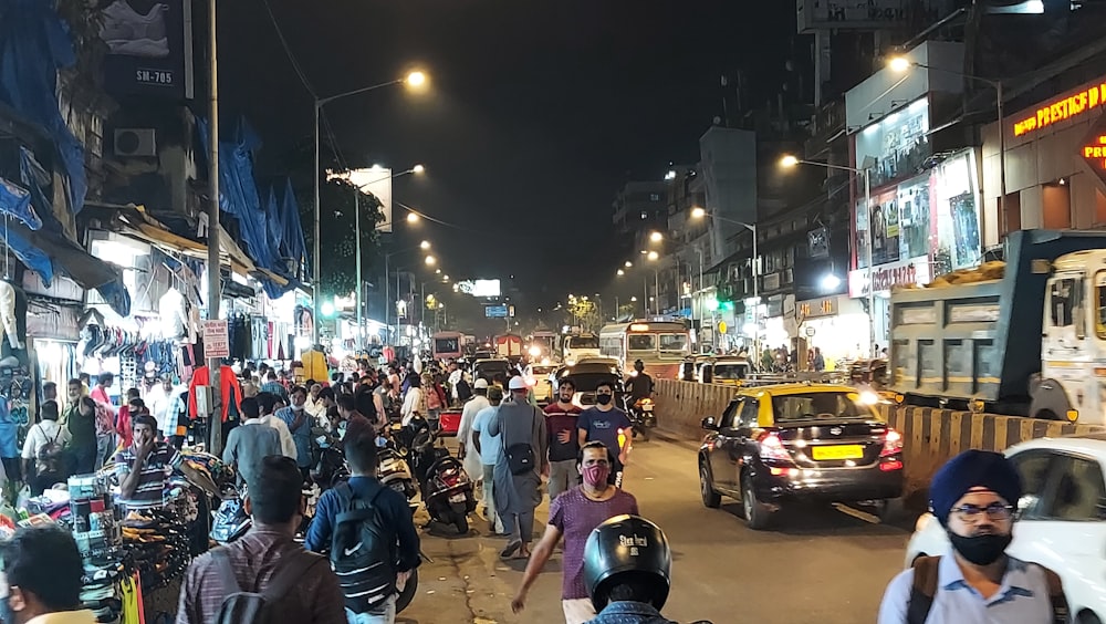 a crowded city street at night filled with people