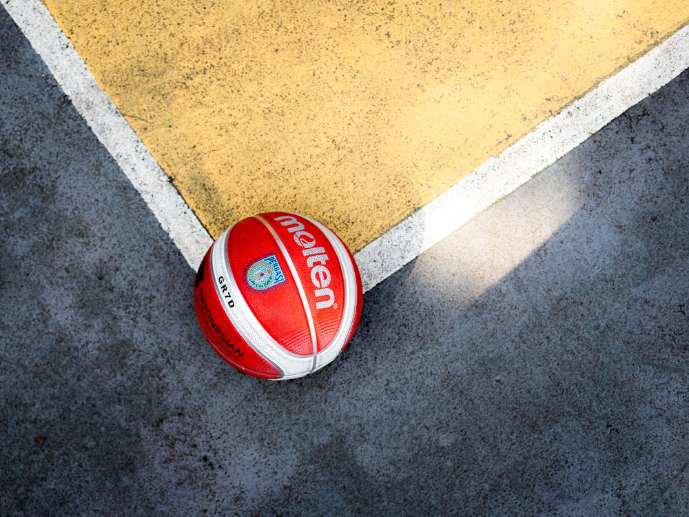 a red and white ball laying on the ground
