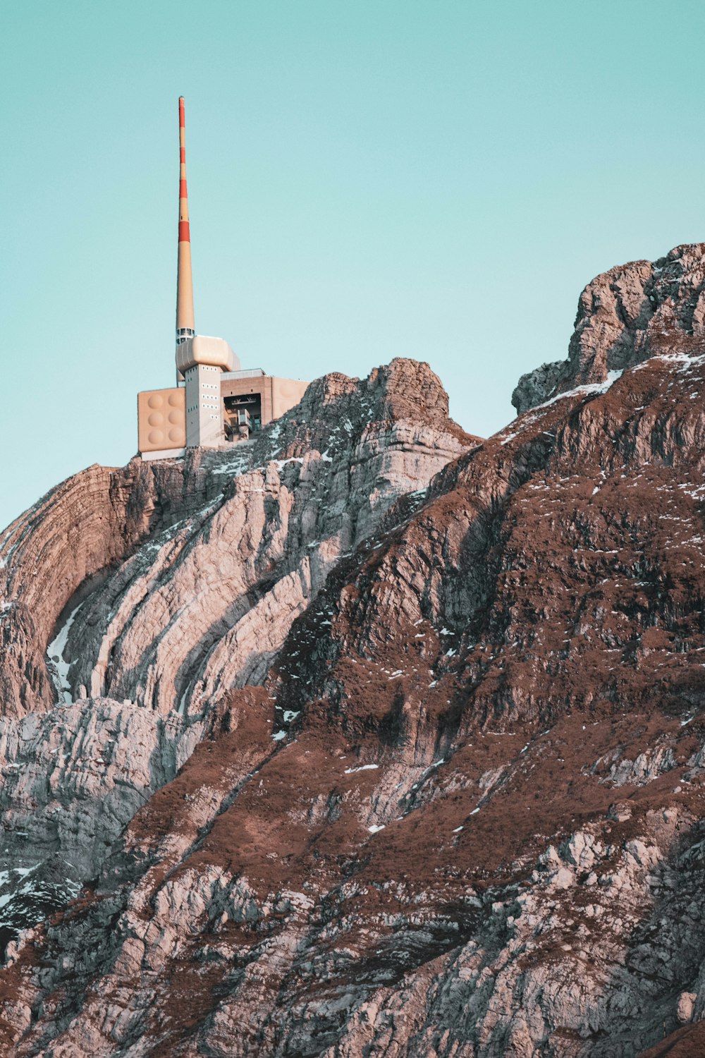 a building on top of a mountain with a sky background