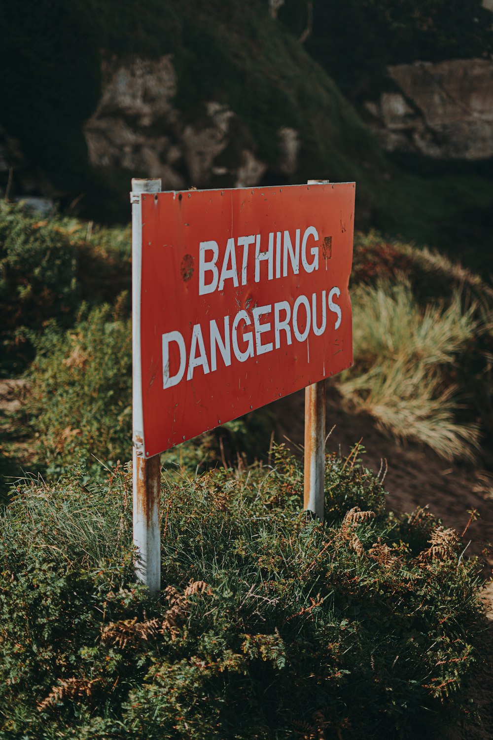 a red and white sign that says bathing dangerous