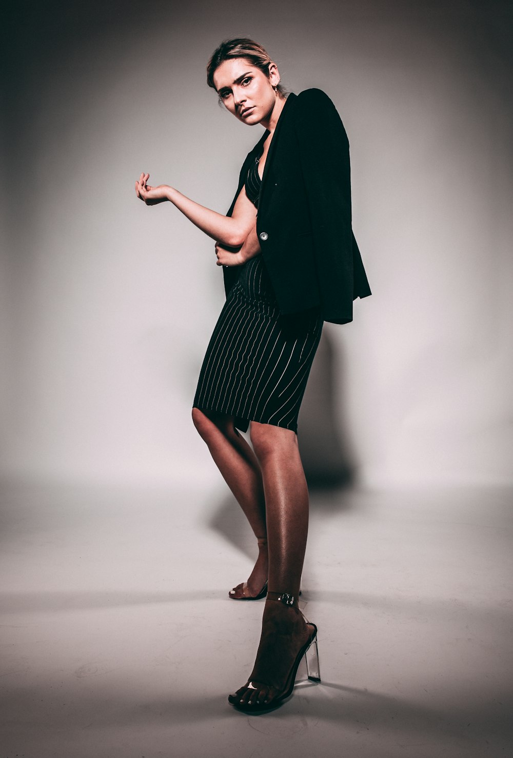 a woman in a black dress and heels posing for a picture