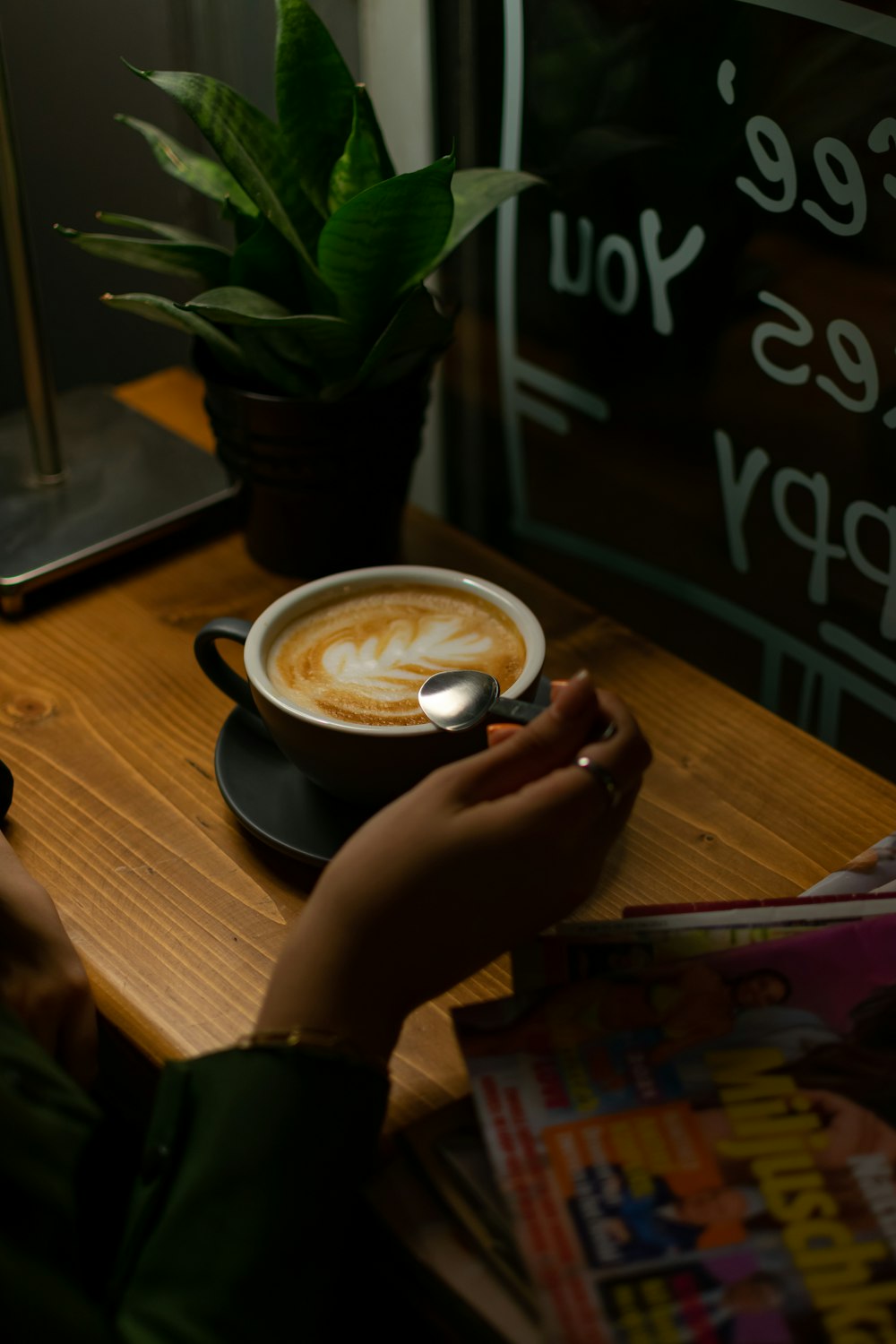 a person sitting at a table with a cup of coffee