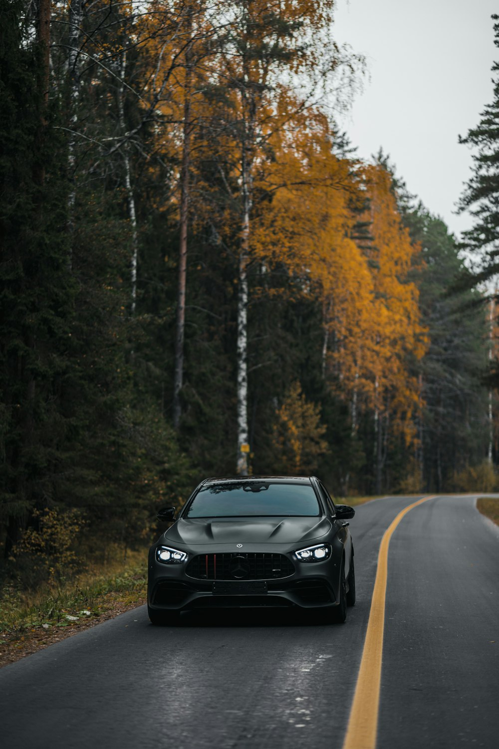 a black sports car driving down the road