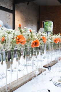 a long table with a bunch of flowers in vases