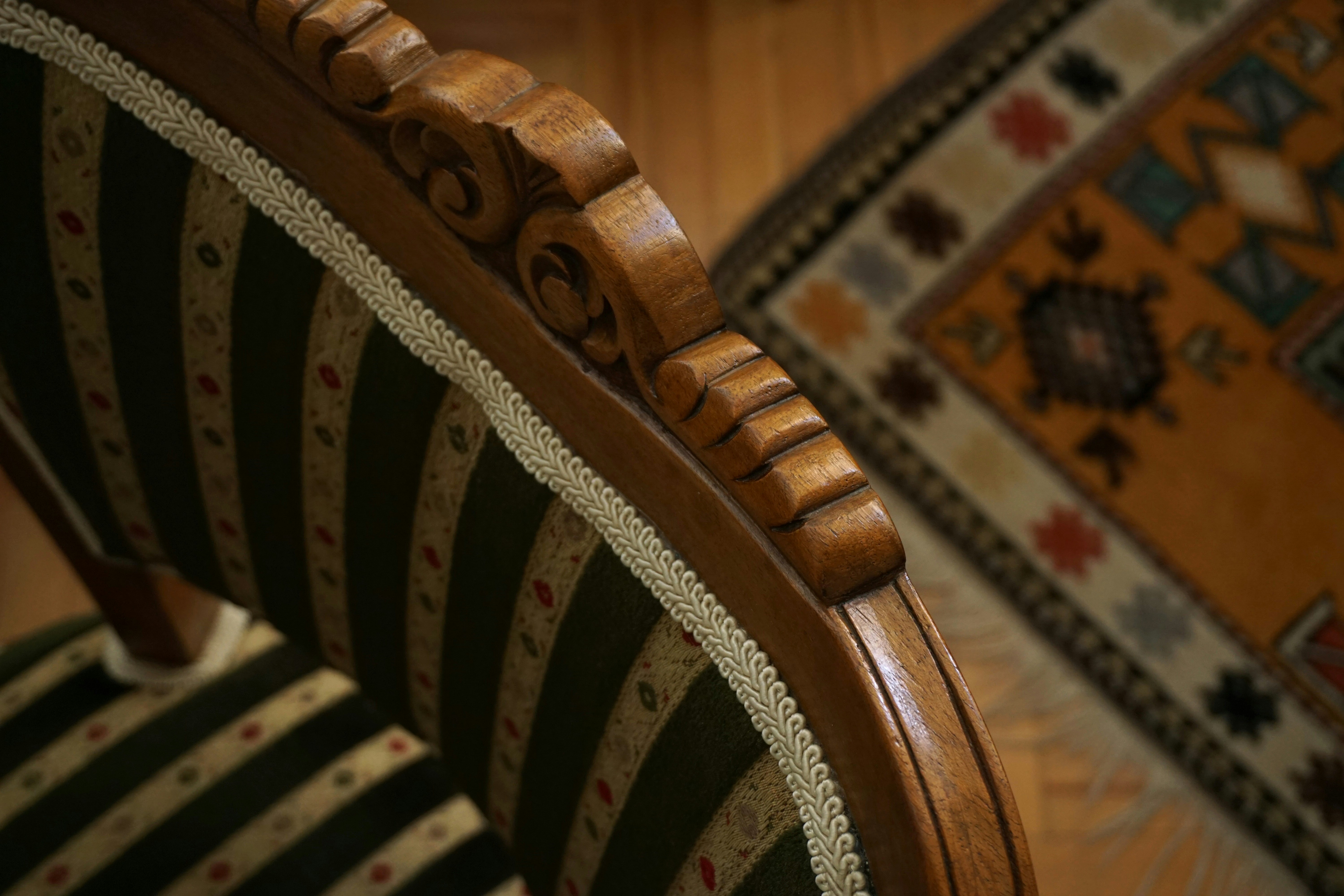 a close up of a chair with a rug in the background