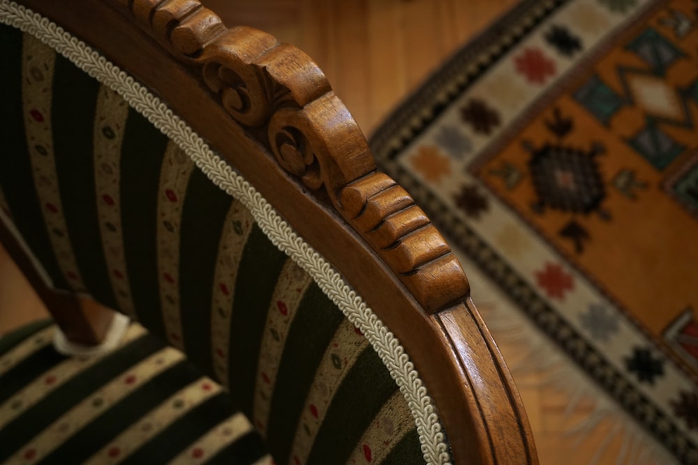 a close up of a chair with a rug in the background
