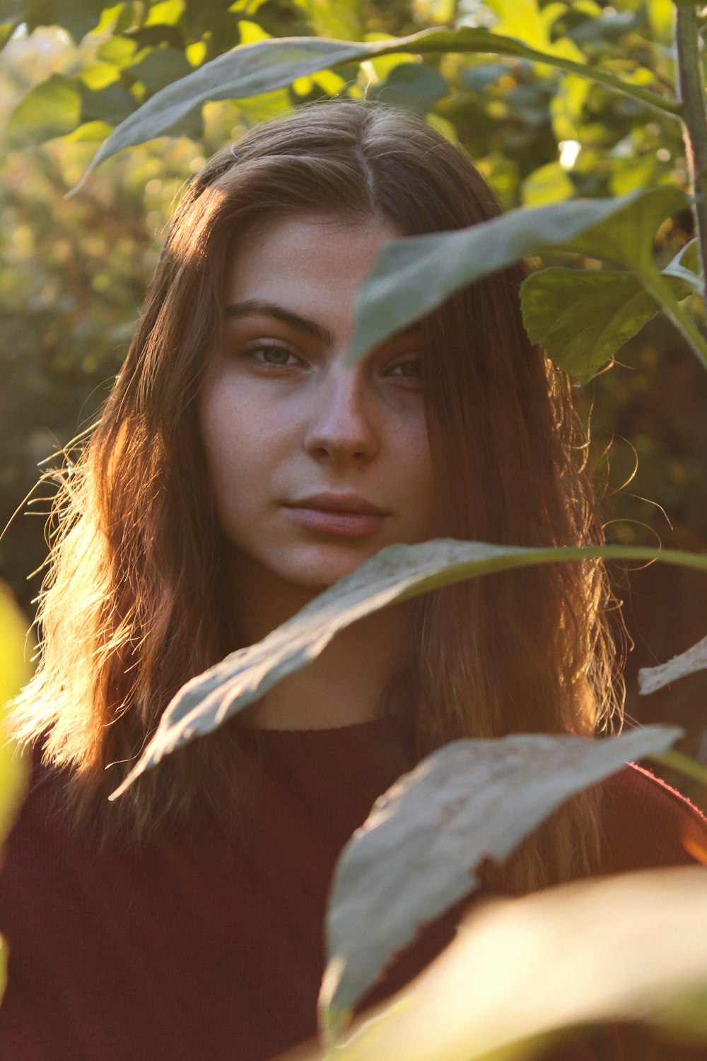 a woman standing in front of some leaves