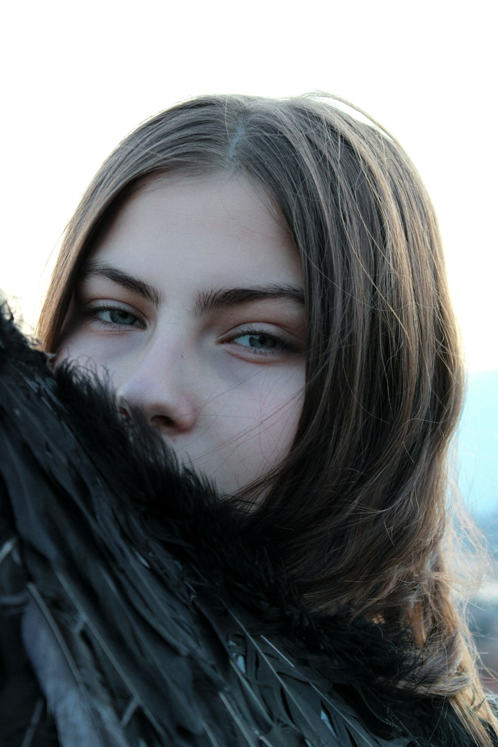 a woman with long hair wearing a black coat