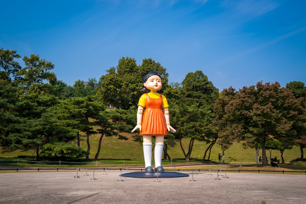 une grande statue d’une femme en robe orange