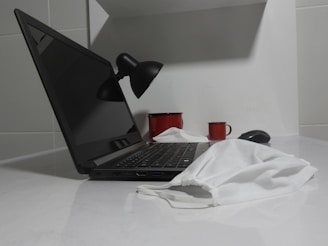 a laptop computer sitting on top of a white counter