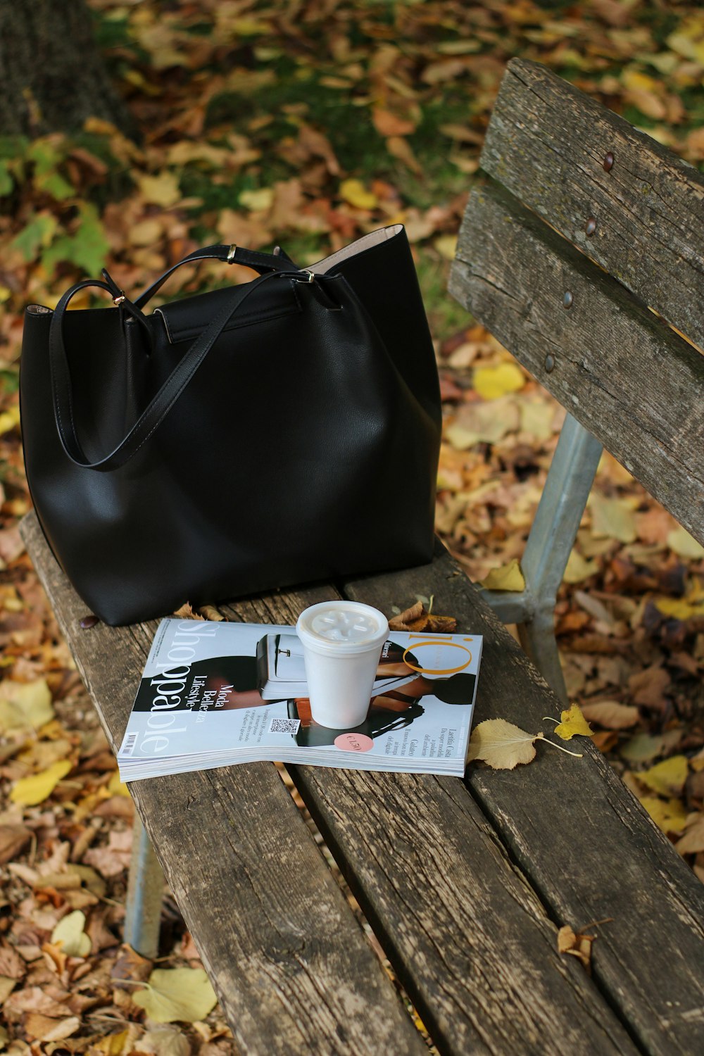 a black purse sitting on top of a wooden bench