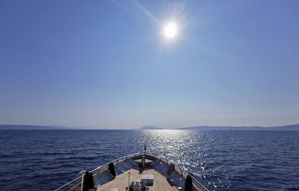 the sun is shining over the ocean from a boat