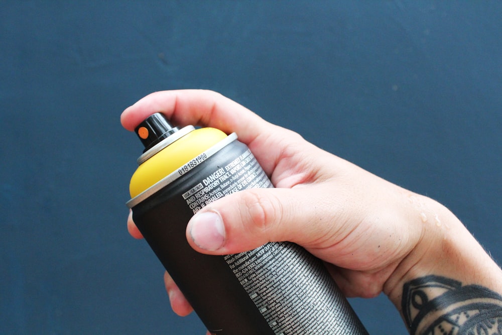 a person holding a black and yellow water bottle