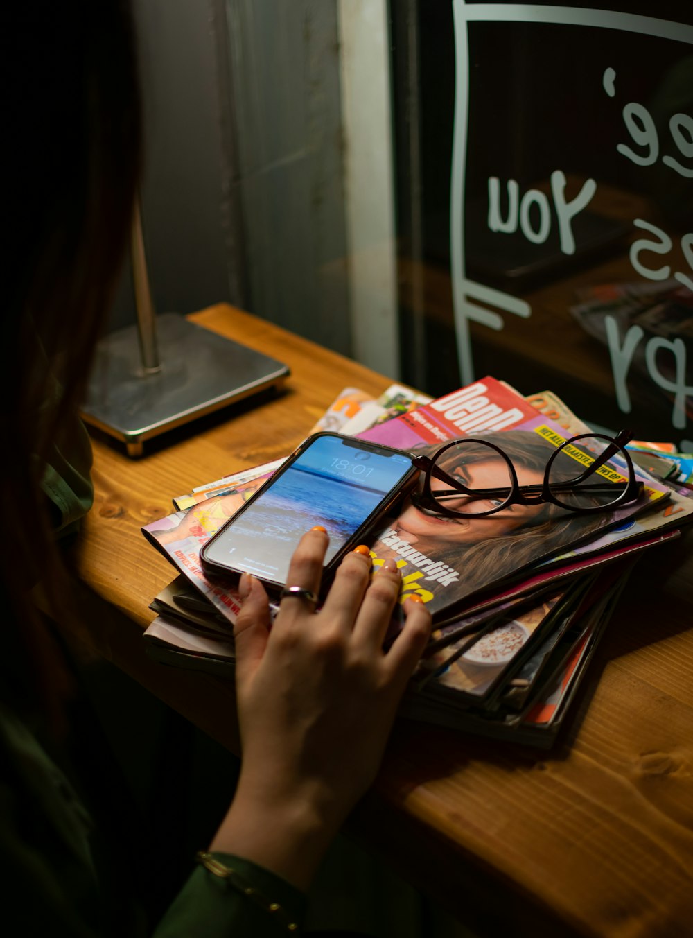 a woman sitting at a table using a cell phone