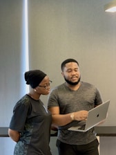 a man and woman looking at a laptop