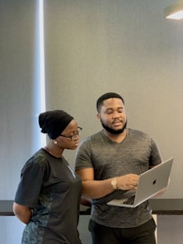 a man and woman looking at a laptop