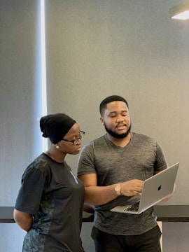 a man and woman looking at a laptop