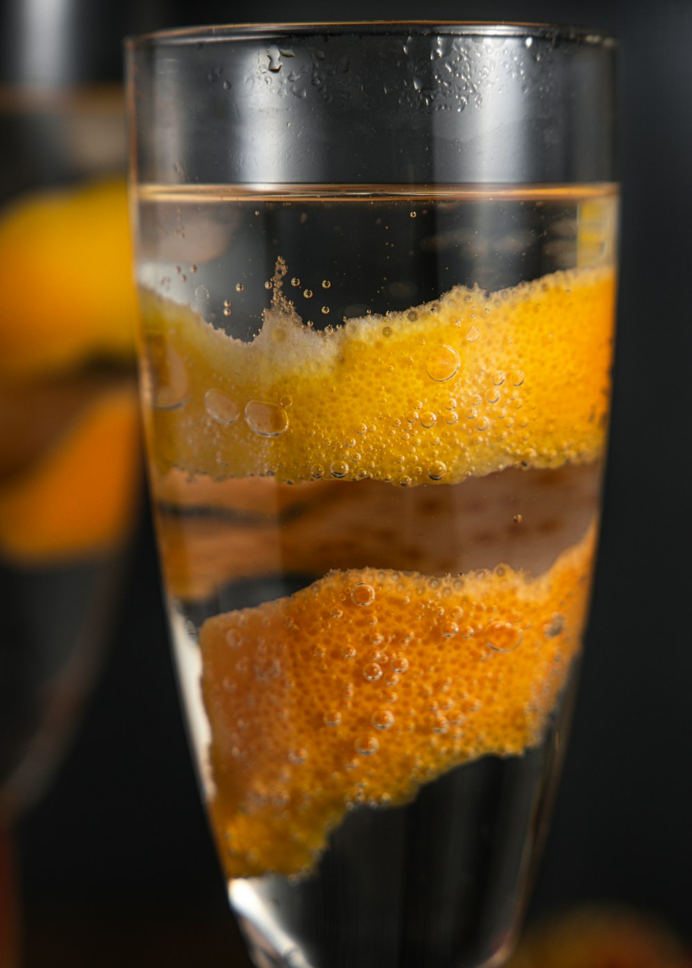 a glass filled with liquid and orange peels