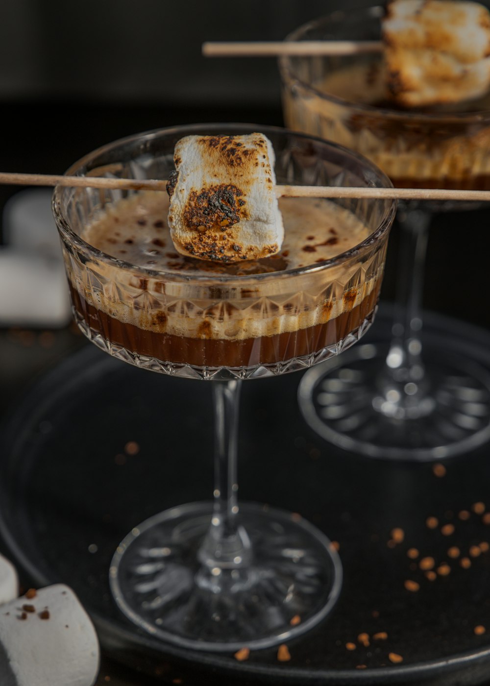 two desserts with marshmallows in a glass on a tray