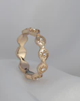 a gold ring with diamonds on a white surface